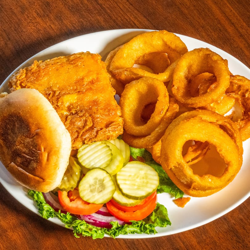 Scores on 33rd's fried chicken burger with onion rings, pickles, tomatoes, and lettuce.
